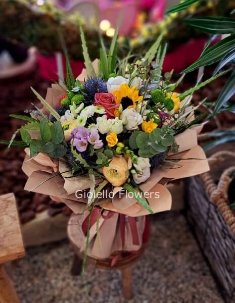 Bouquet di fiori assortiti, confezionato con carta kraft