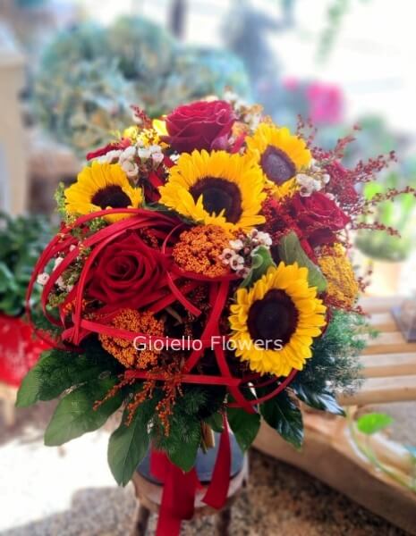 Bouquet di girasoli e rose bianche con verde e fiori complementari