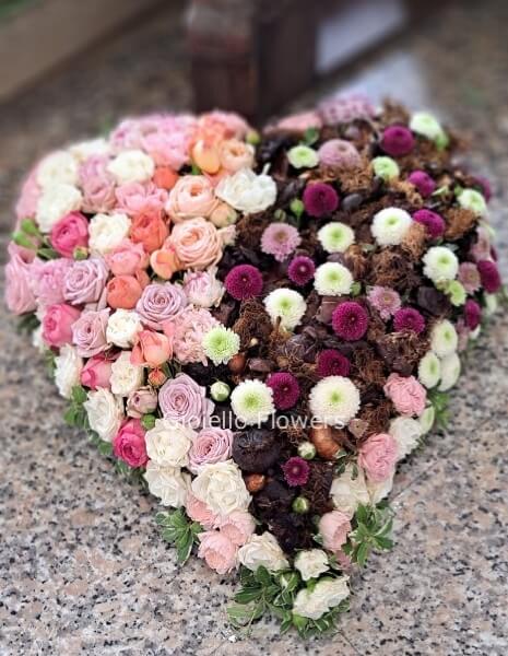 Cuore con fiori di stagione dalle tonalità del rosa