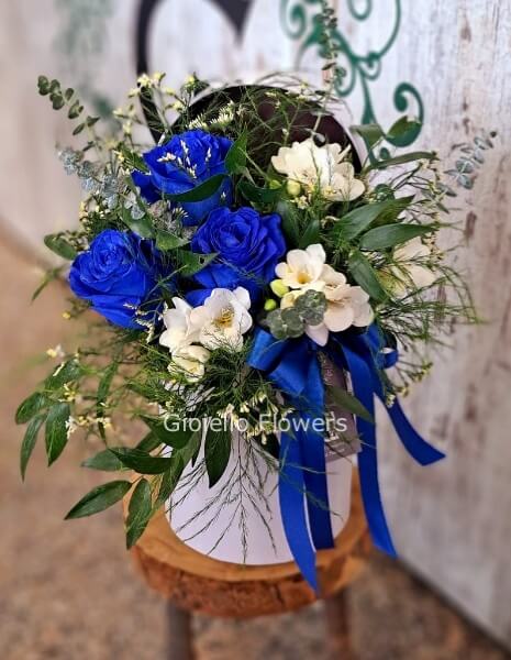 Cappelliera con rose blu e fiori di stagione 