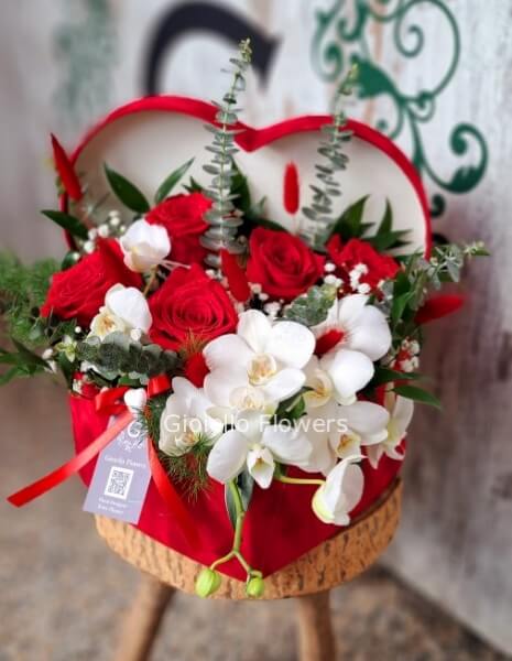Cappelliera a cuore di rose rosse e fiori di stagione colori tenui