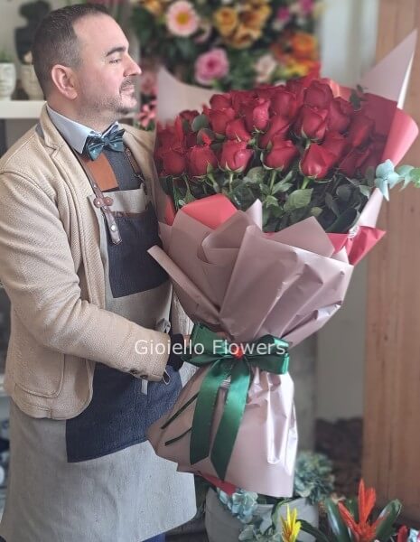 Fascio di rose rosse con fiori complementari e verde decorativo