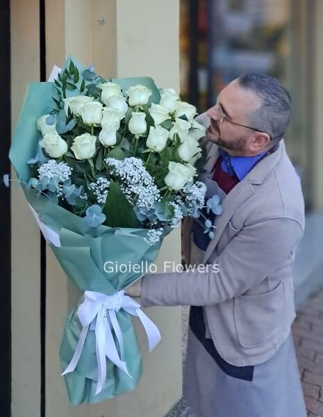 Fascio di rose rosa con fiori complementari e verde decorativo