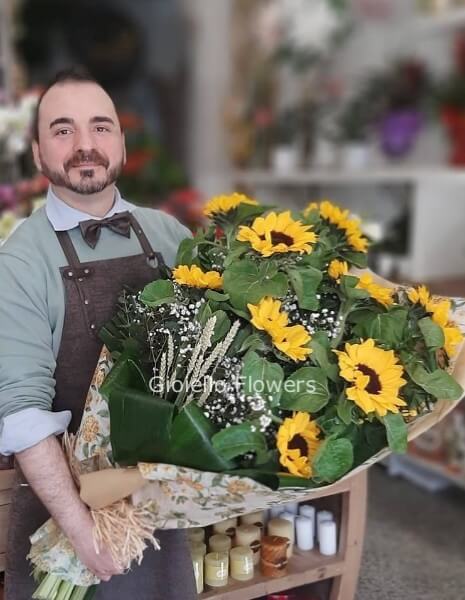 Fascio di girasoli, fiori complementari e verde decorativo
