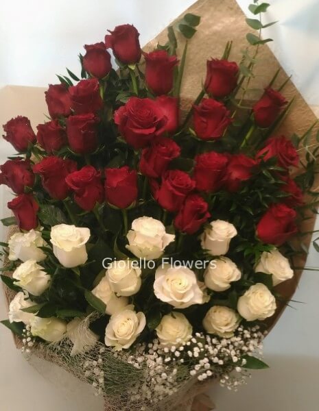 Fascio di rose rosse e bianche con verde decorativo