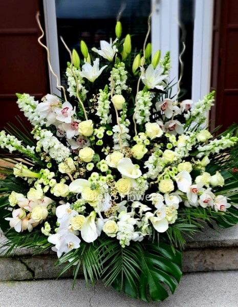 Cesto funebre con orchidee e fiori di stagione tonalità del bianco