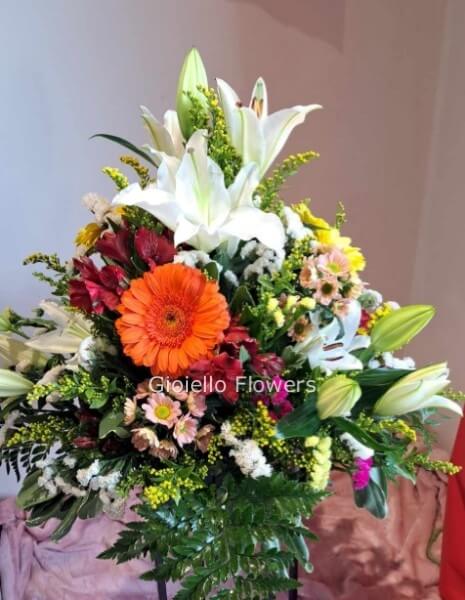 Ciotola Funebre di fiori e colori assortiti di stagione scritta e nastro